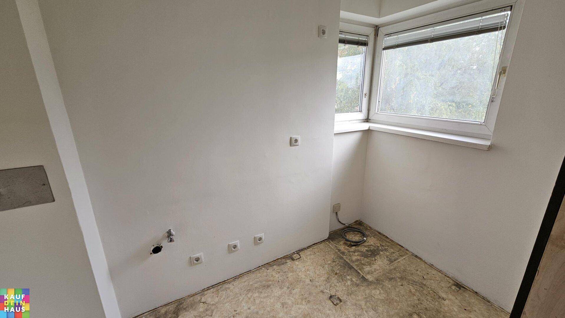 Kleiner Raum mit Eckfenster und Anschlüssen für eine Küche oder einen Hauswirtschaftsraum.
