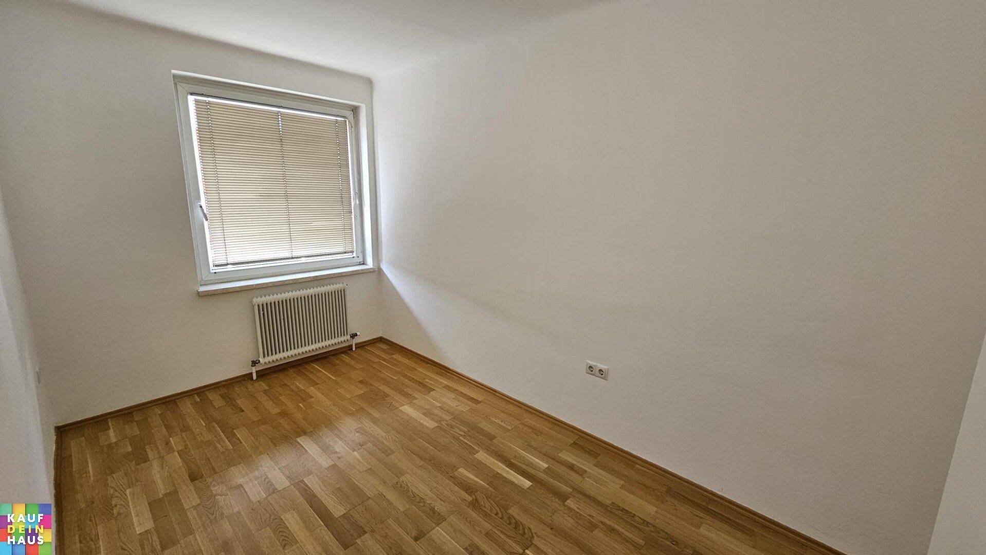 Kleineres Schlafzimmer mit hellem Parkettboden und einem Fenster für ausreichend Tageslicht.