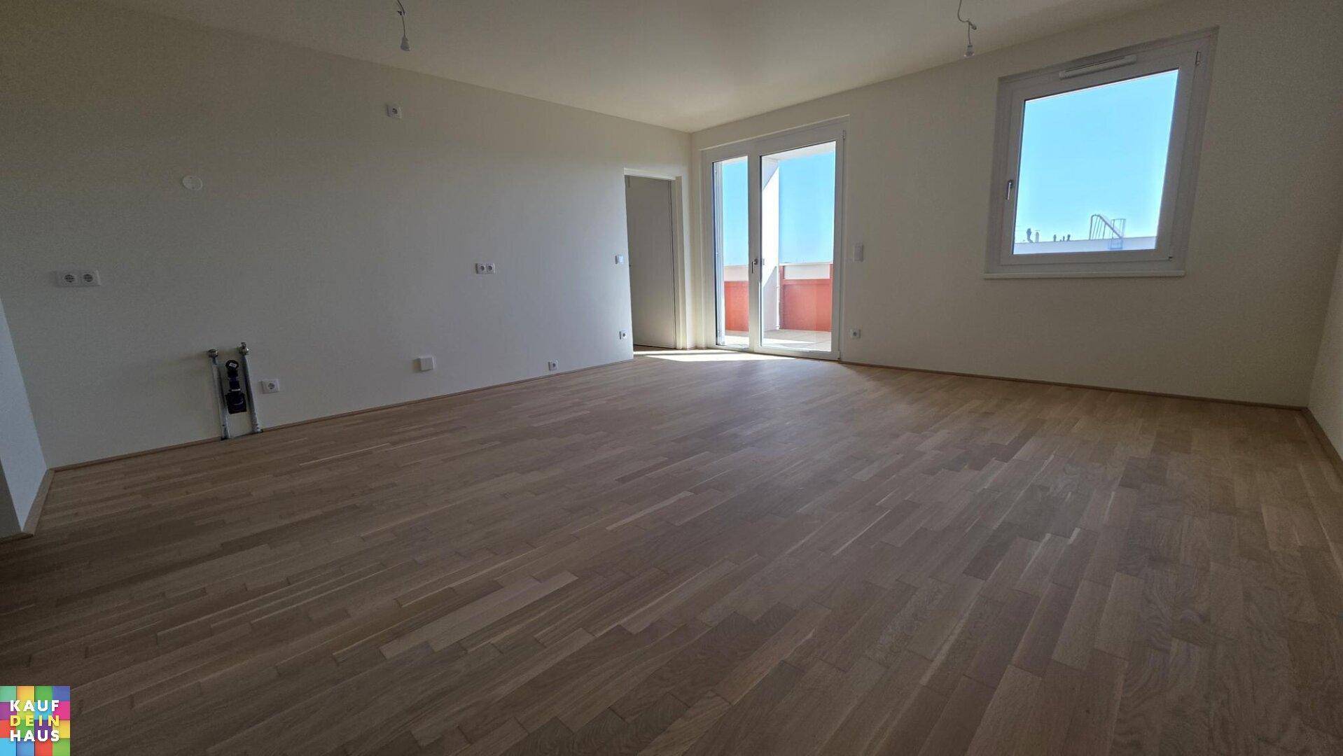 Geräumiges, helles Zimmer mit Holzplankenboden und Zugang zu einem Balkon.