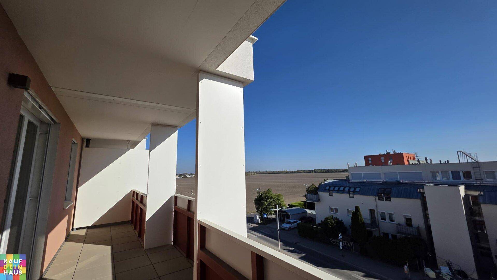 Sonniger Balkon mit Blick auf die weite Landschaft und die darunterliegende Straße.