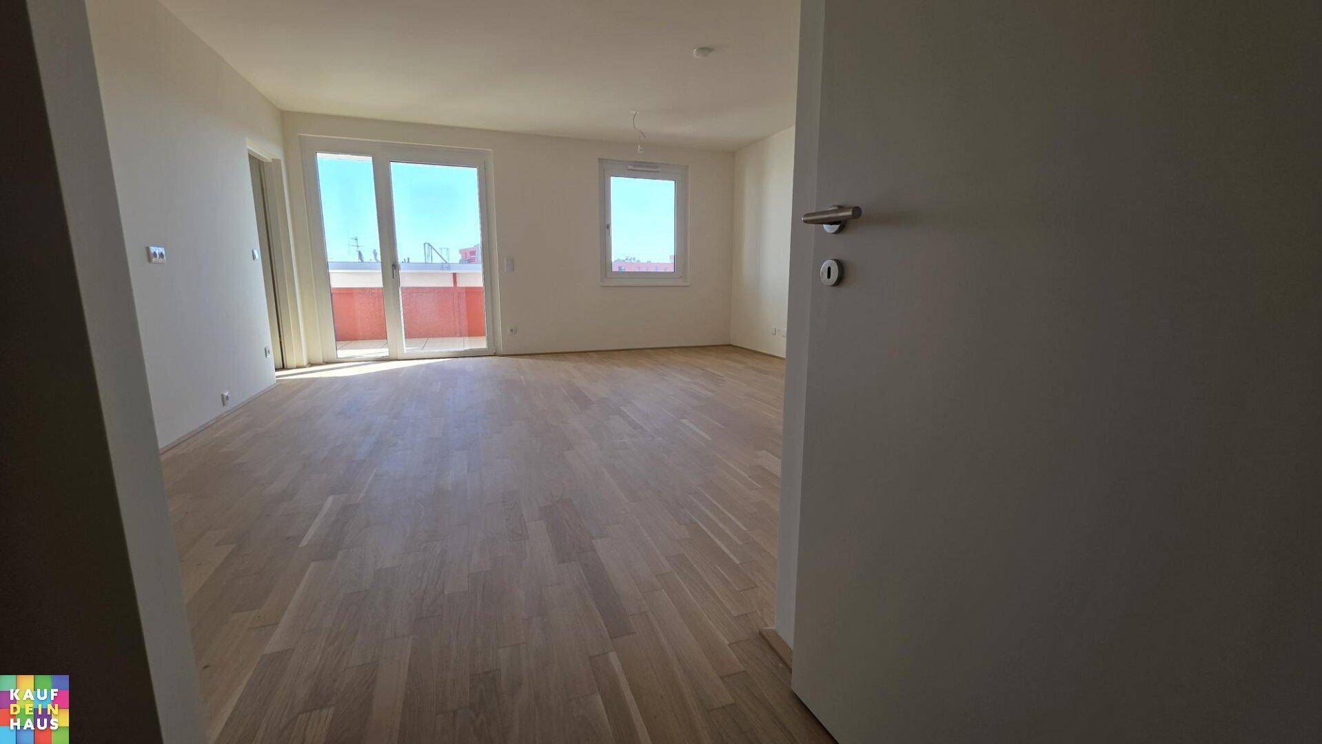 Großes, lichtdurchflutetes Zimmer mit Holzplankenboden und direktem Zugang zum Balkon.