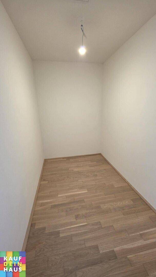 Kleiner, heller Abstellraum mit Holzplankenboden und weißen Wänden.