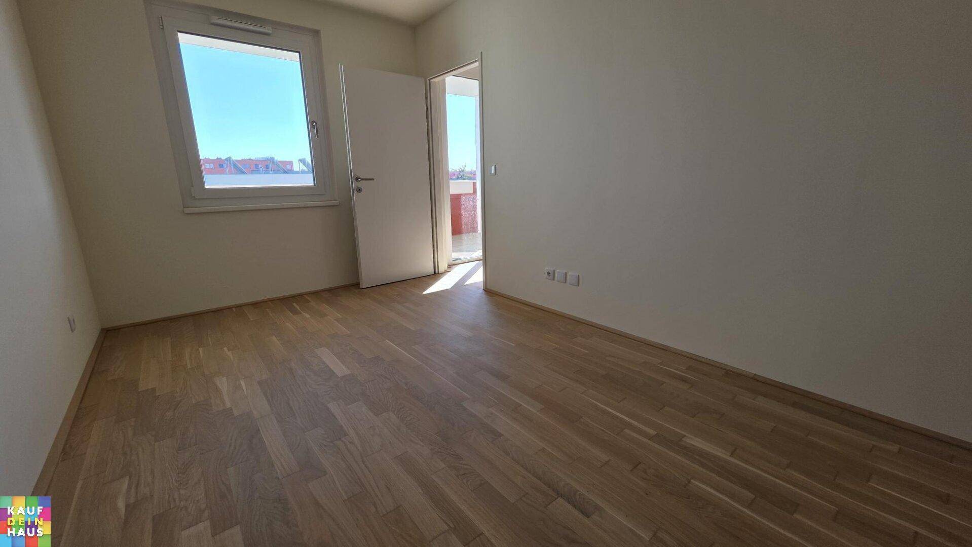 Helles Schlafzimmer mit Parkettboden und direktem Zugang zum Balkon.