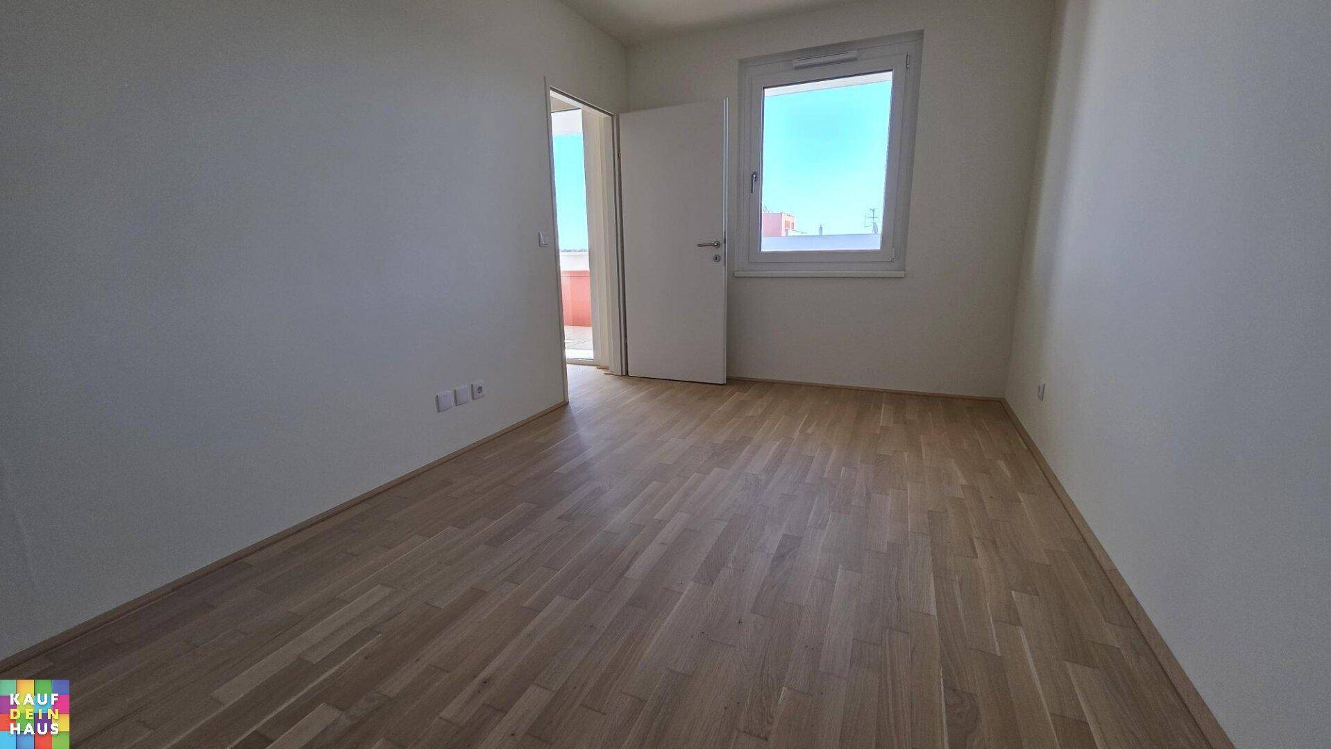 Helles Schlafzimmer mit Parkettboden und direktem Zugang zum Balkon.