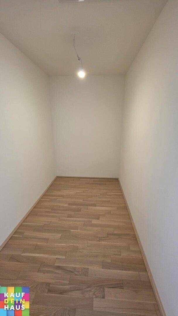 Praktischer Abstellraum mit Parkettboden und einfacher Beleuchtung.
