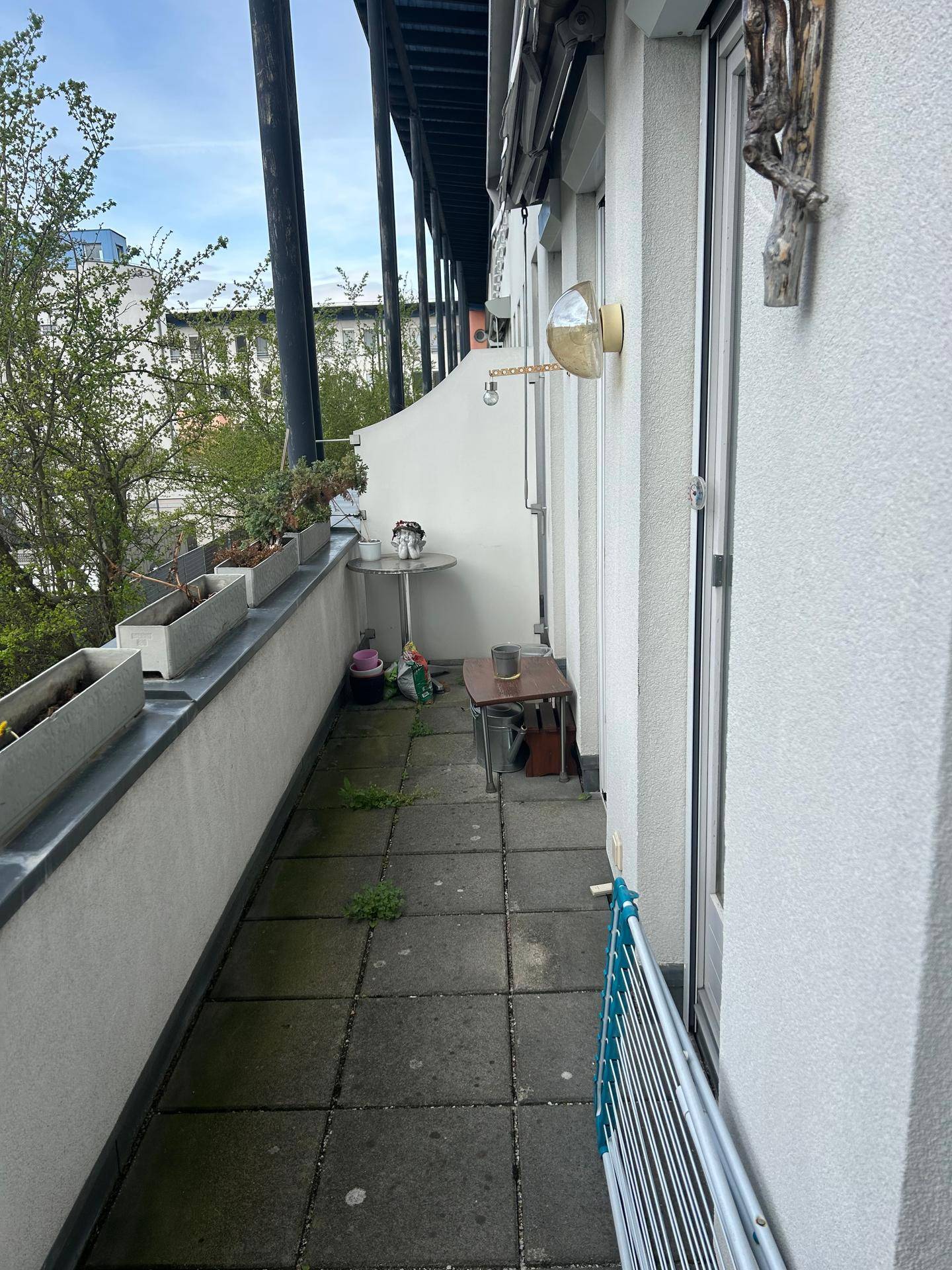 Langer, schmaler Balkon mit Fliesenboden und einem kleinen Tisch für entspannte Momente.