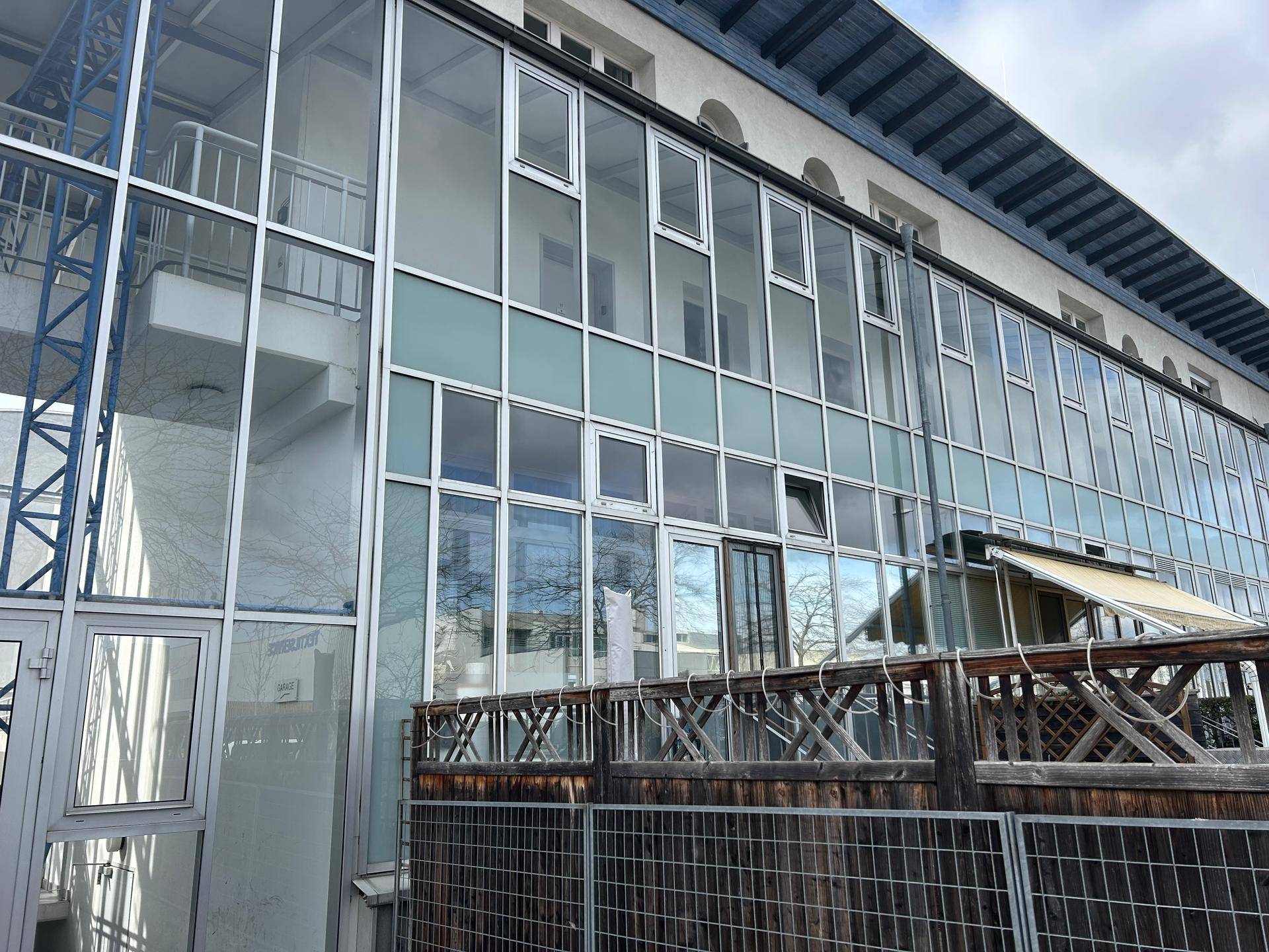 Moderne Gebäudefassade mit großen Glasflächen und Balkonen, die viel Licht hereinlassen.