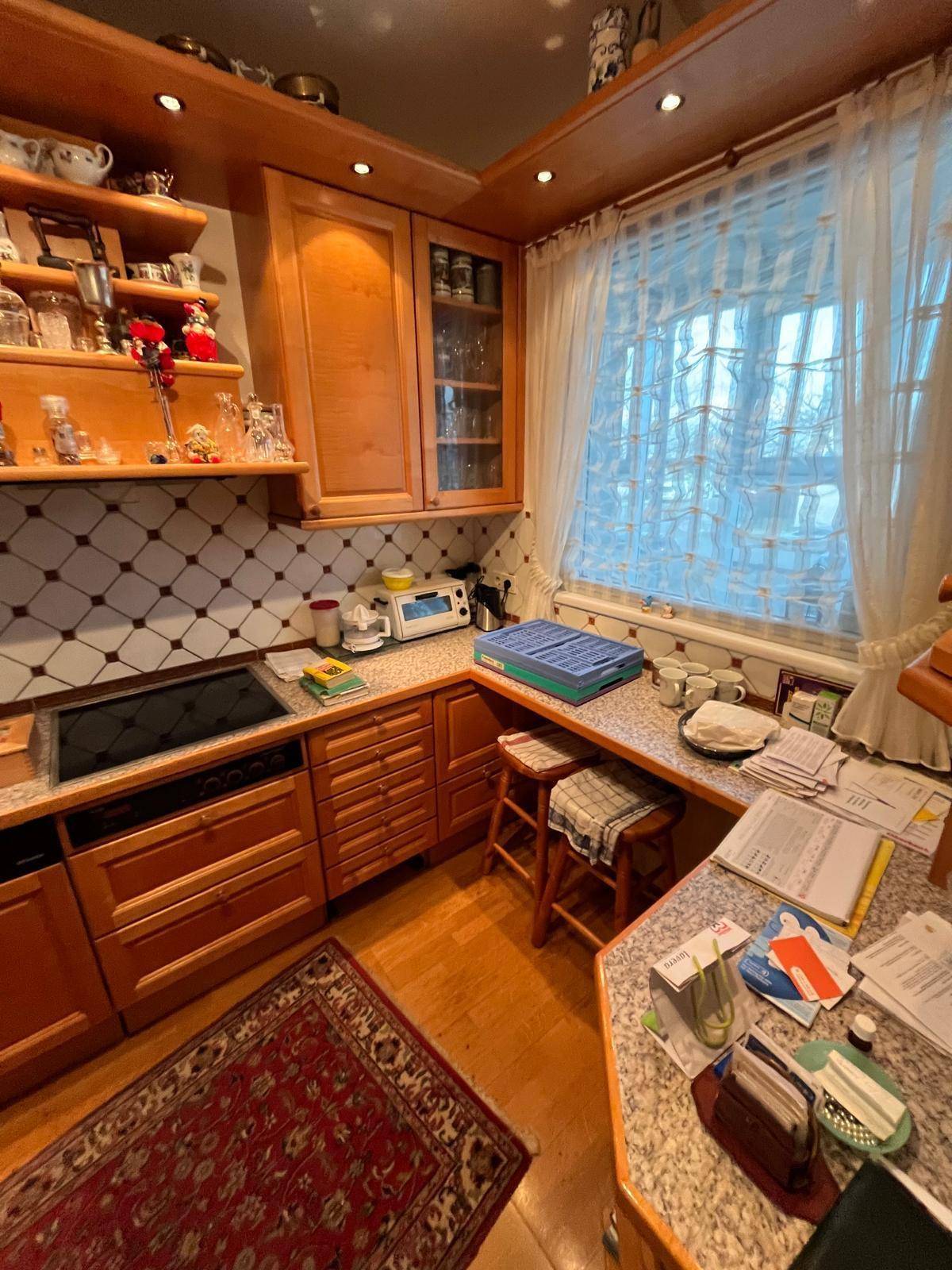 Gemütliche Küche mit Holzschränken, Granitarbeitsplatte und einem Fenster für Tageslicht.