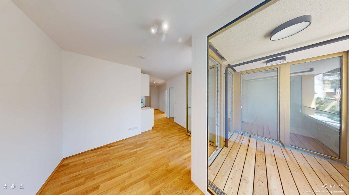 Heller Wohnbereich mit Holzboden und direktem Zugang zu einer verglasten Loggia mit Holzdeck.