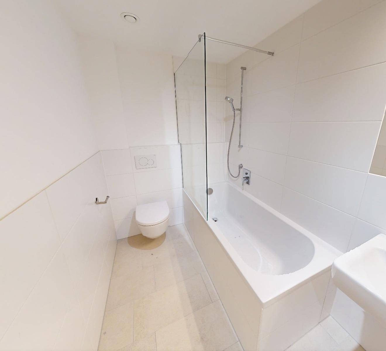Modernes Badezimmer mit Badewanne, Dusche und Wand-WC, hell gefliest.