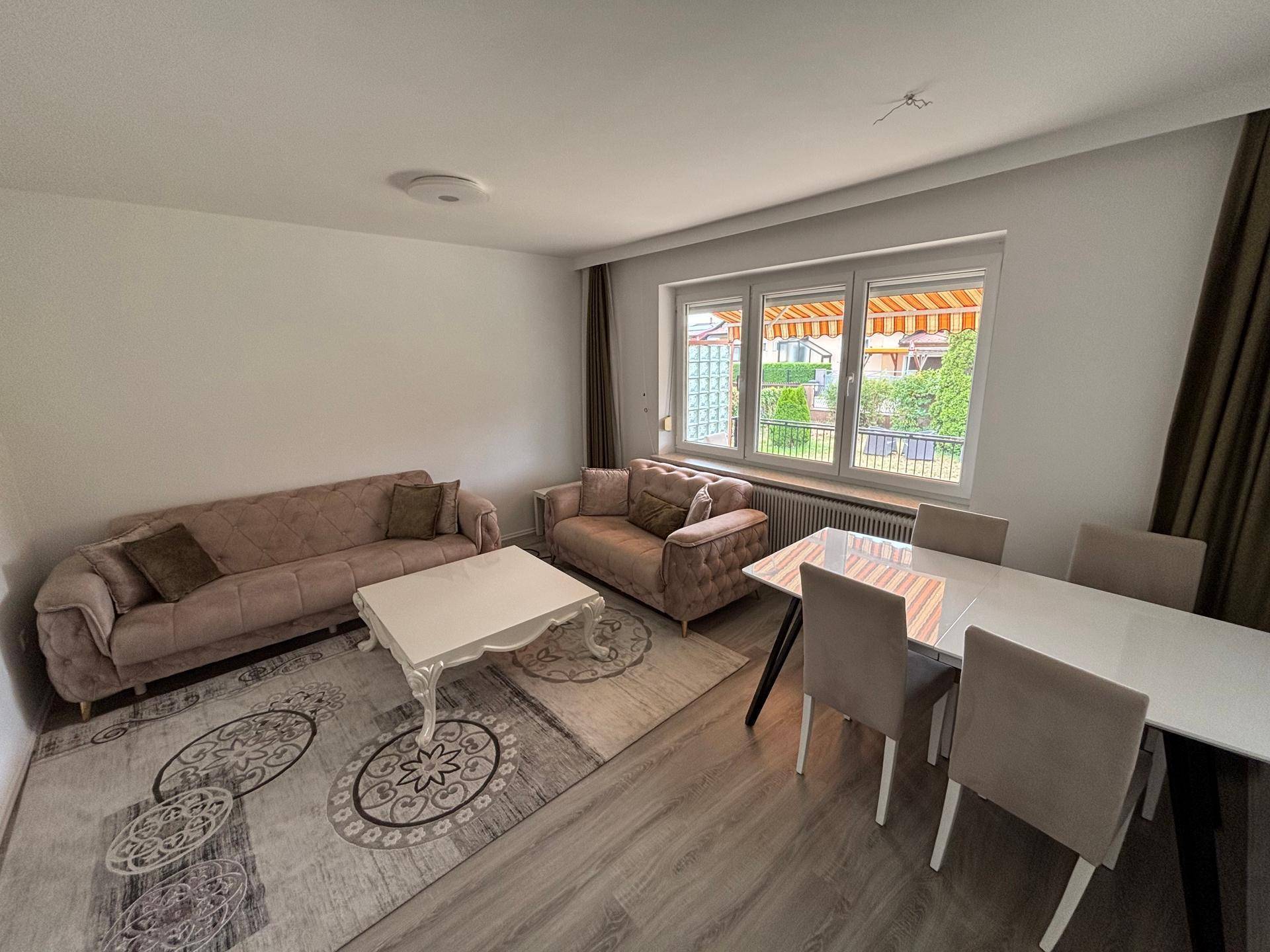 Offener Wohn-Essbereich mit bequemen Sofas, Esstisch und Blick auf die Terrasse.