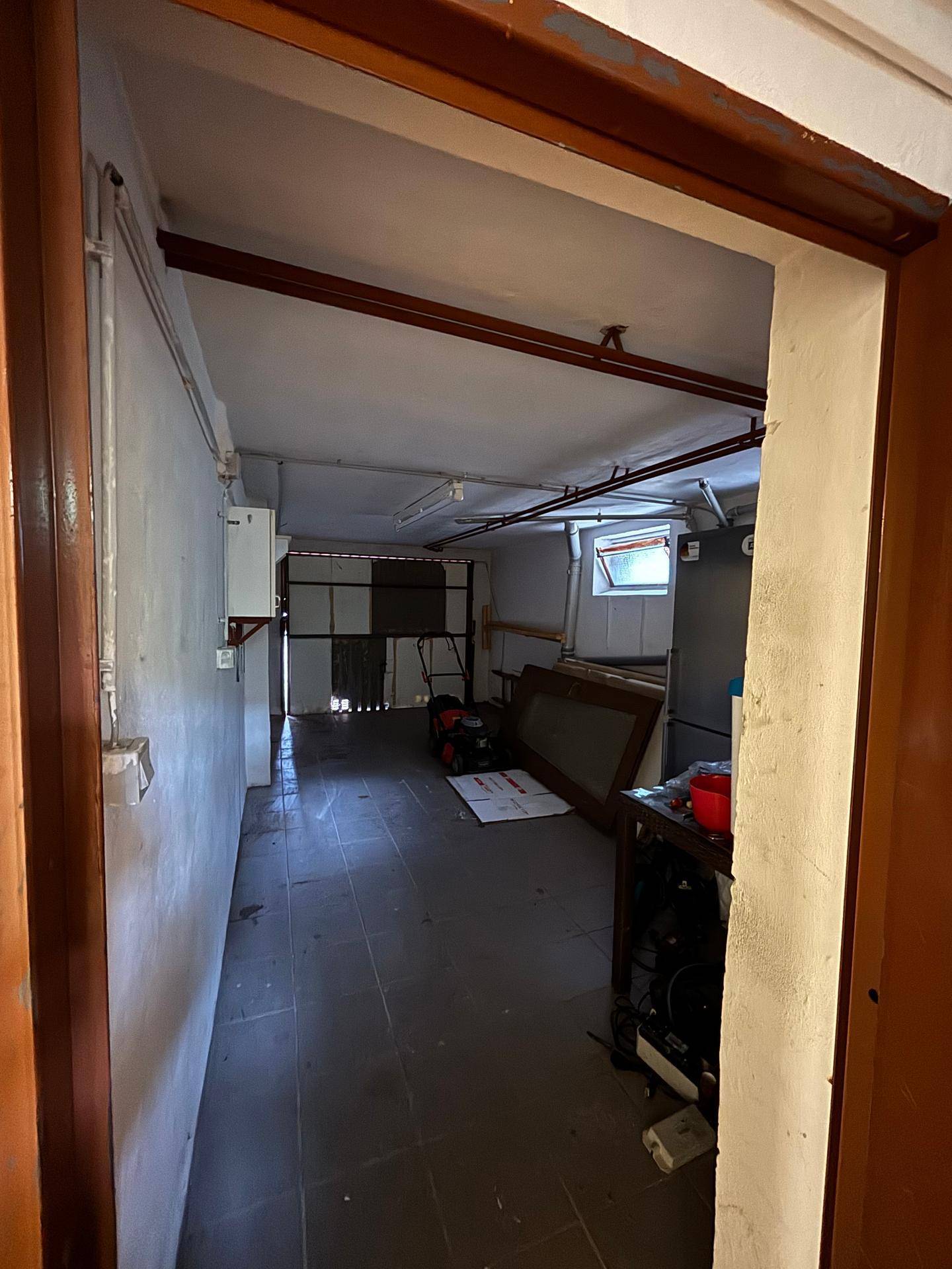 Kellergarage mit Fliesenboden und ausreichend Platz für Fahrzeuge und Lagerung.
