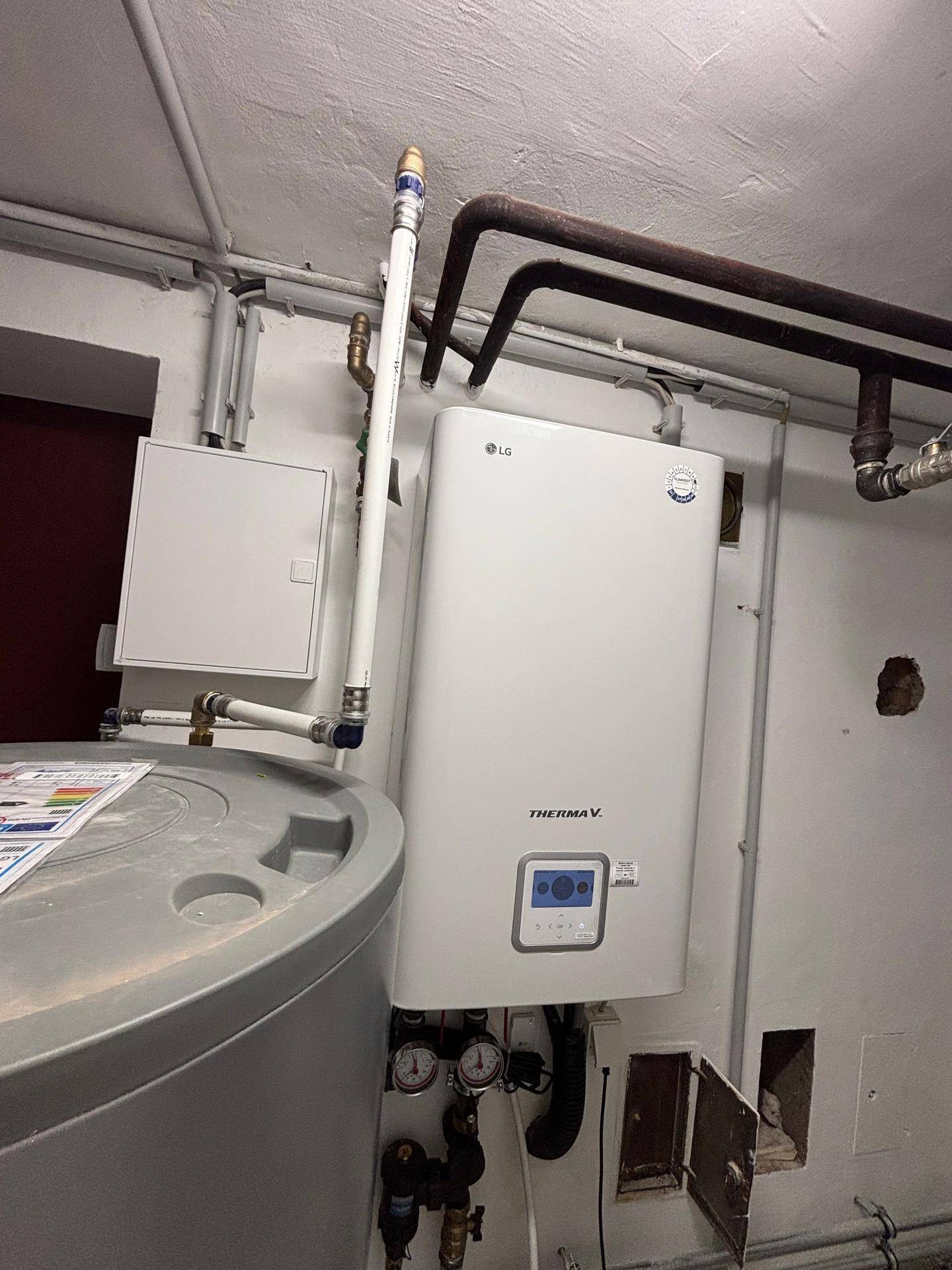 Innenansicht eines Hauswirtschaftsraums mit moderner LG Therma V Wärmepumpe und Wassertank.