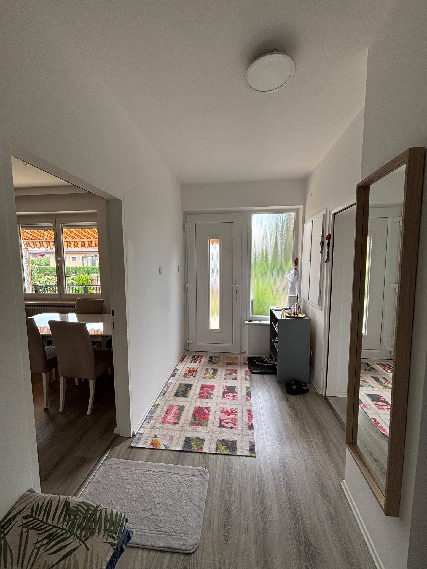 Freundlicher Eingangsbereich mit Laminatboden, Garderobe und Blick in den Essbereich.