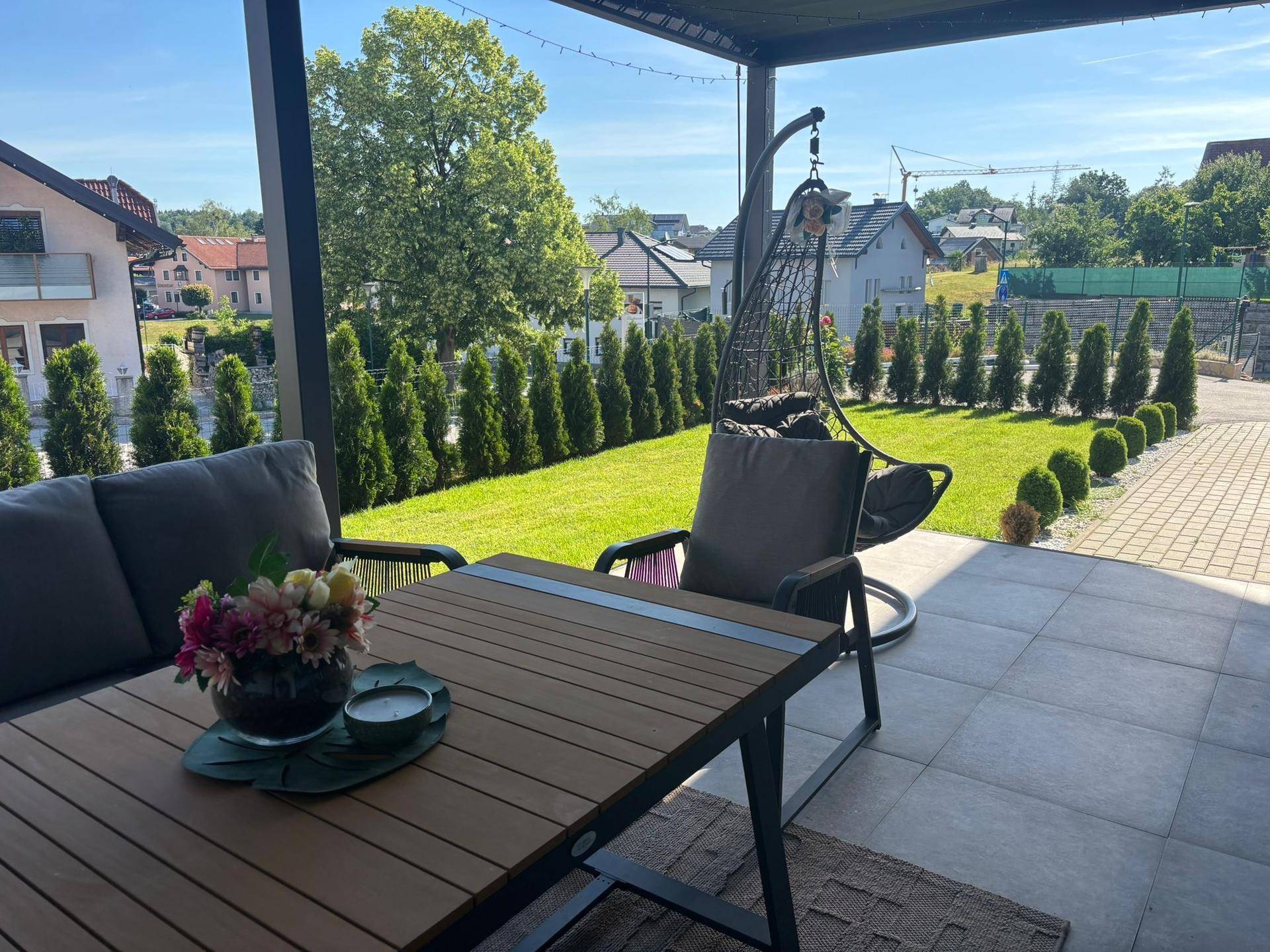 Gemütliche Terrasse mit modernen Gartenmöbeln und Blick ins Grüne.