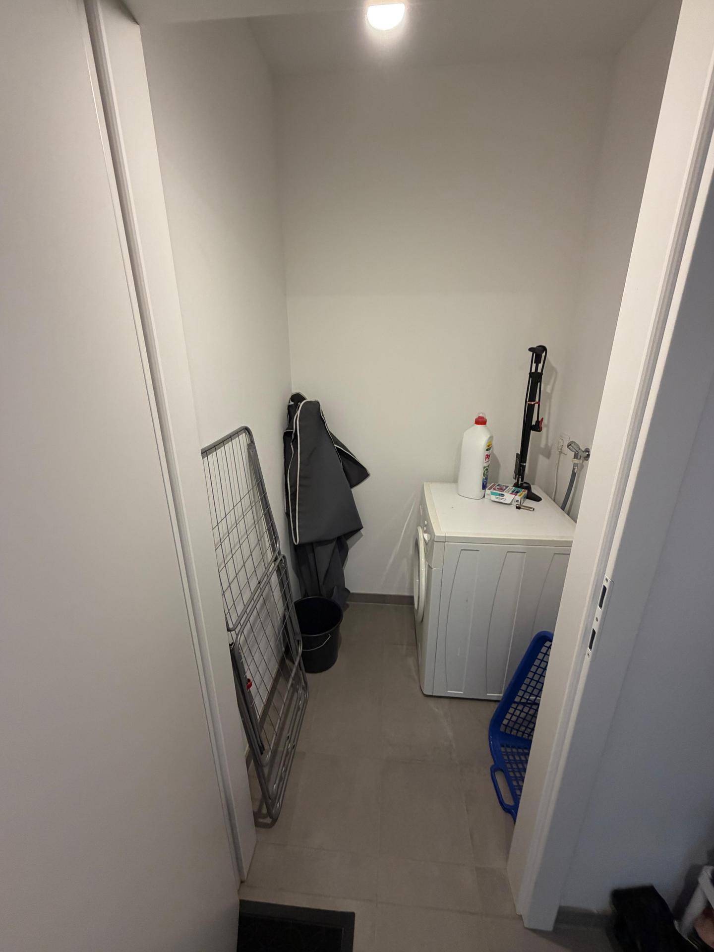 Praktischer Hauswirtschaftsraum mit Waschmaschine und ausreichend Platz zum Wäschetrocknen.