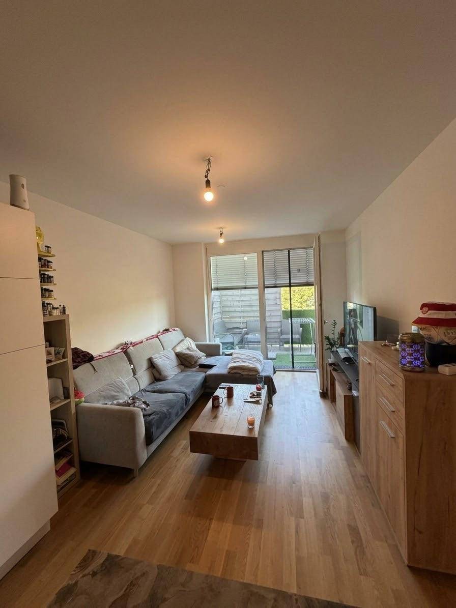 Gemütliches Wohnzimmer mit Sofa, Couchtisch und Zugang zu einem privaten Außenbereich.