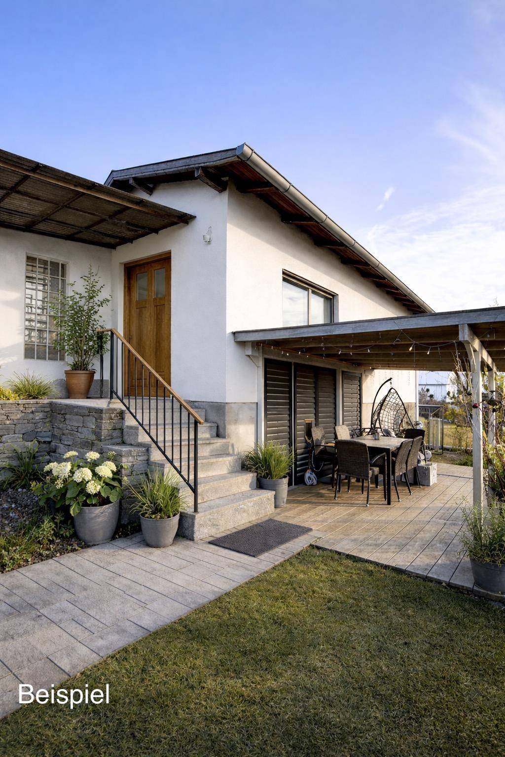 Gemütliche Terrasse mit Holzboden und Essbereich, umgeben von Grünpflanzen und einem Zugang zum Haus.