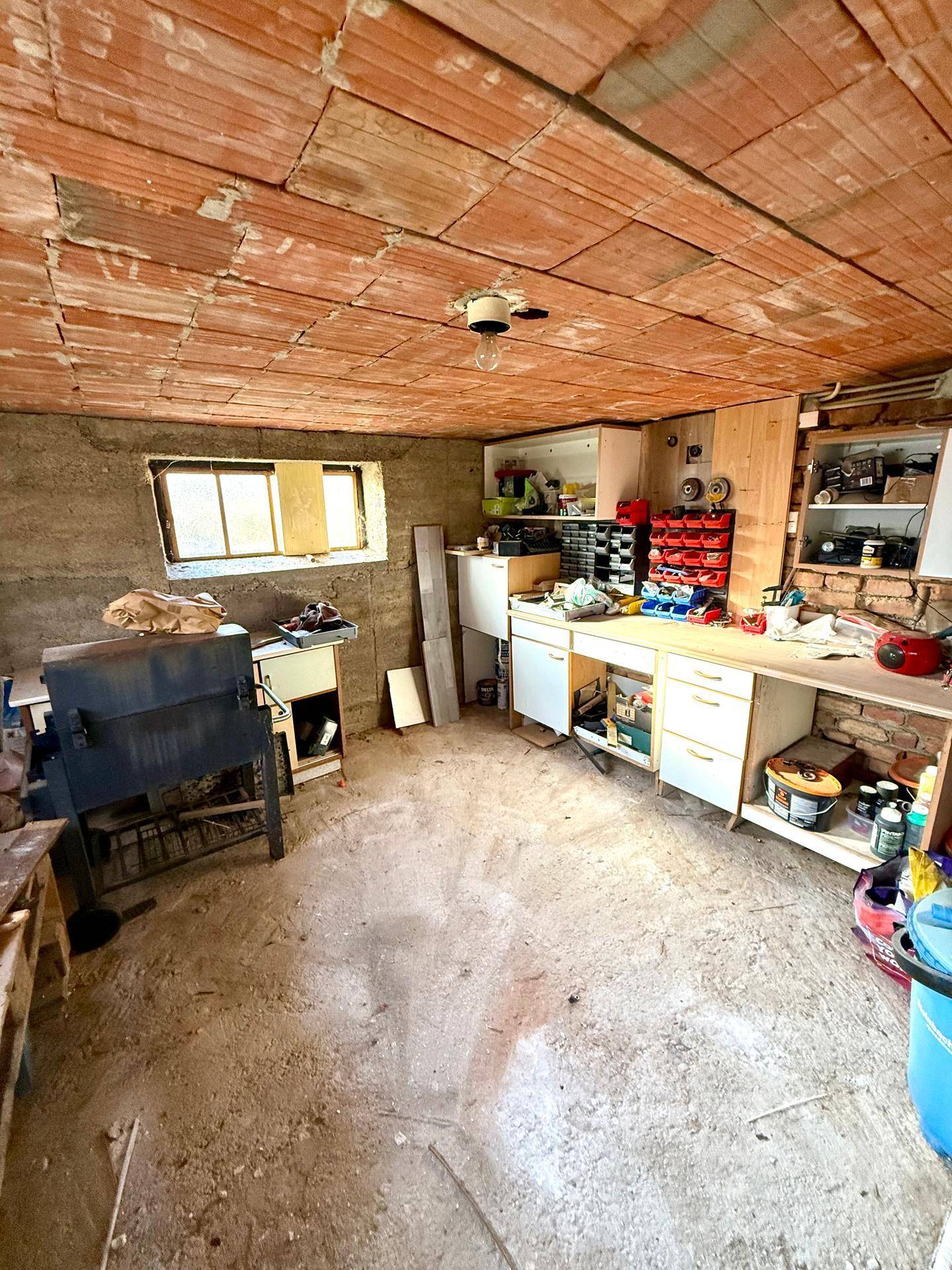 Kellerraum mit Werkbank und Lagerflächen, bietet viel Stauraum und Arbeitsfläche.