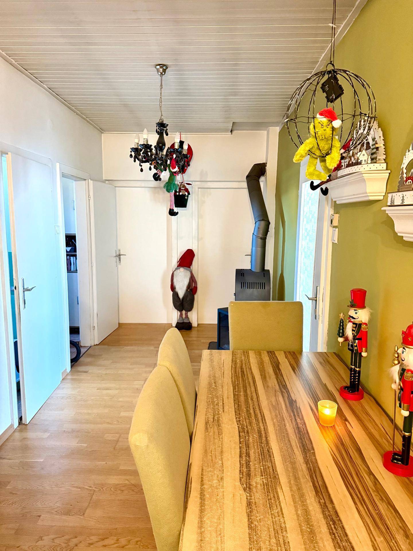 Essbereich mit Holztisch und Holzofen, dekoriert mit festlichen Elementen.