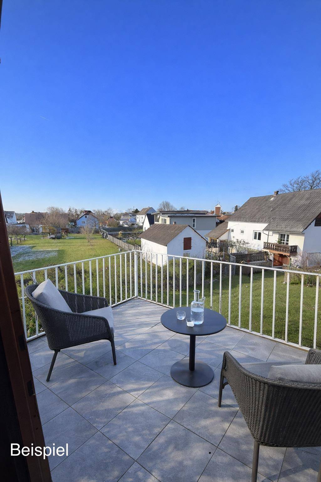 Gemütlicher Balkon mit Fliesenboden und Sitzgelegenheiten, bietet einen weiten Blick ins Grüne.