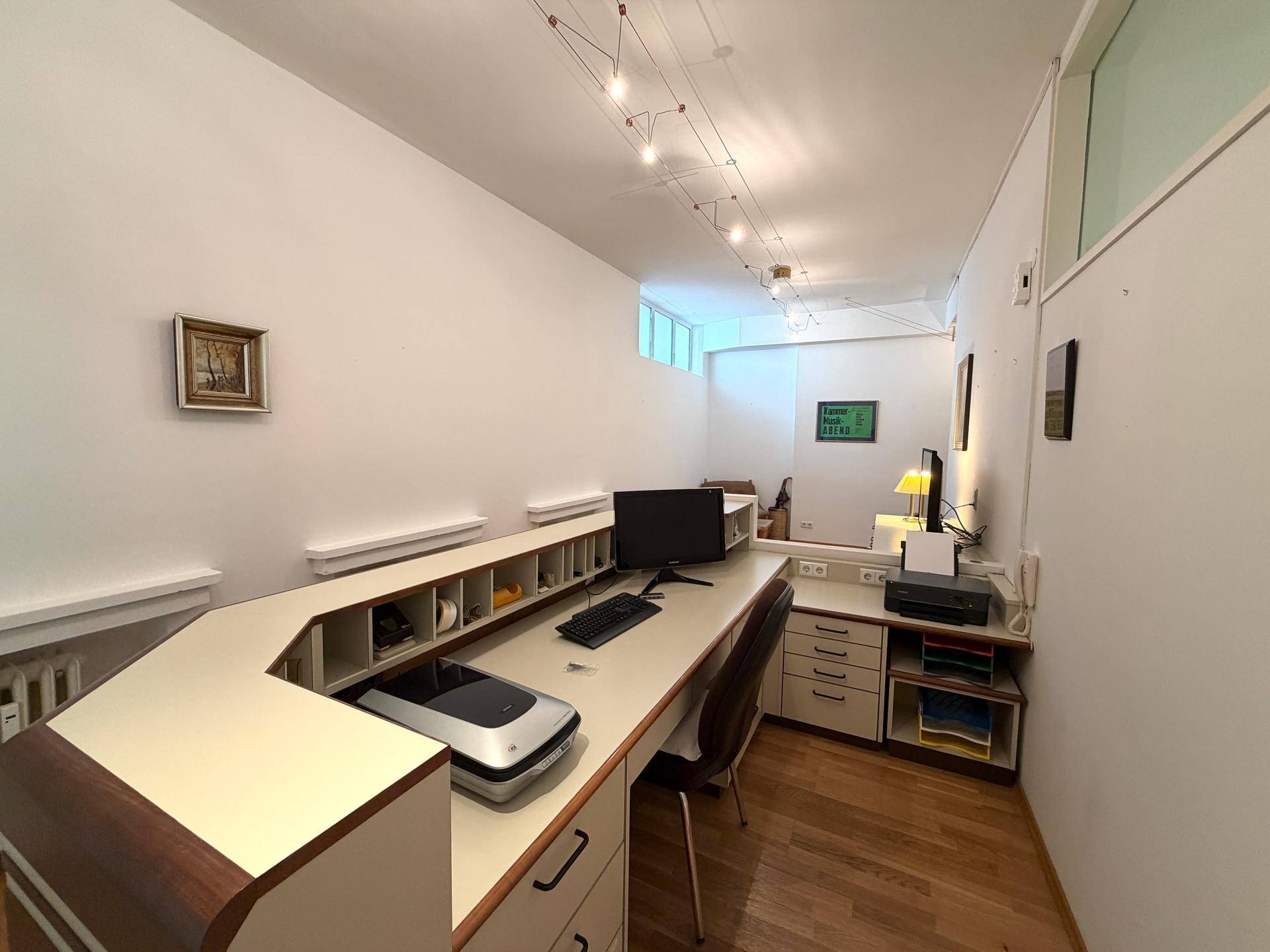 Empfangsbereich oder Büro mit langem Tresen, Computerarbeitsplatz und indirekter Beleuchtung.