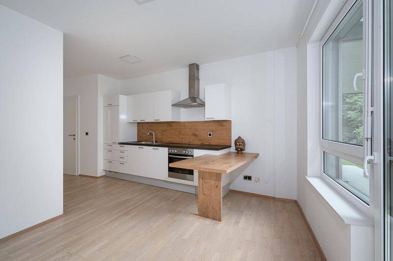 Moderne Küche mit weißen Schränken, integrierten Geräten und einer praktischen Frühstücksbar.
