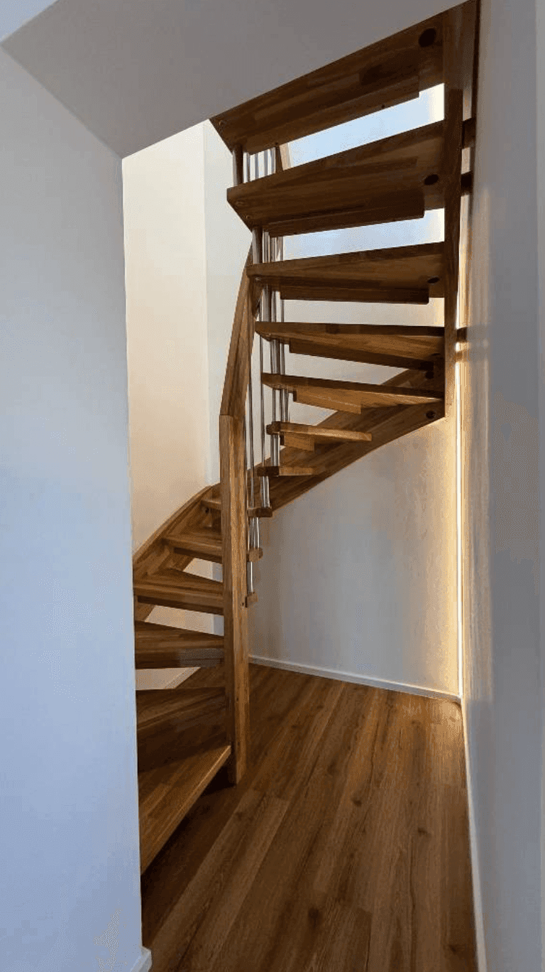 Elegante Holzwendeltreppe mit Metallgeländer, verbindet die Etagen auf stilvolle und platzsparende Weise.