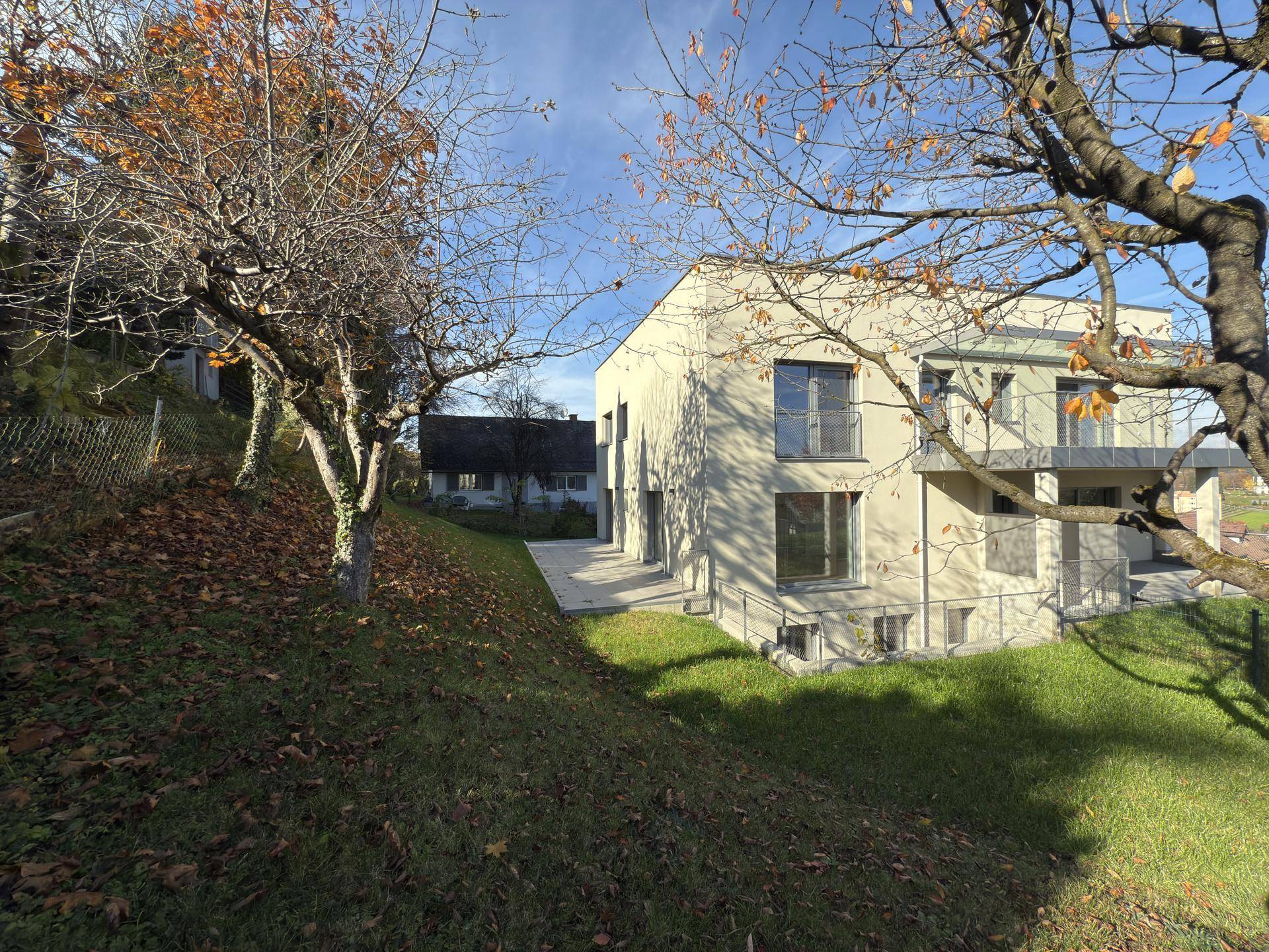 Neubau in grüner Umgebung mit moderner Architektur und gepflegter Außenanlage.