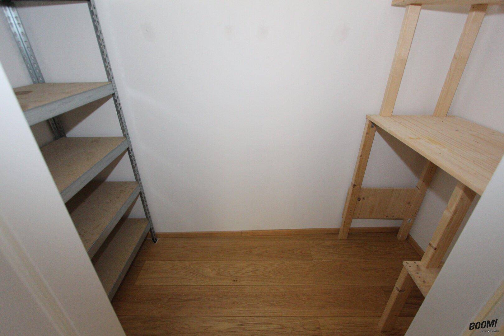 Praktischer Abstellraum mit Regalen für zusätzlichen Stauraum und Holzboden.
