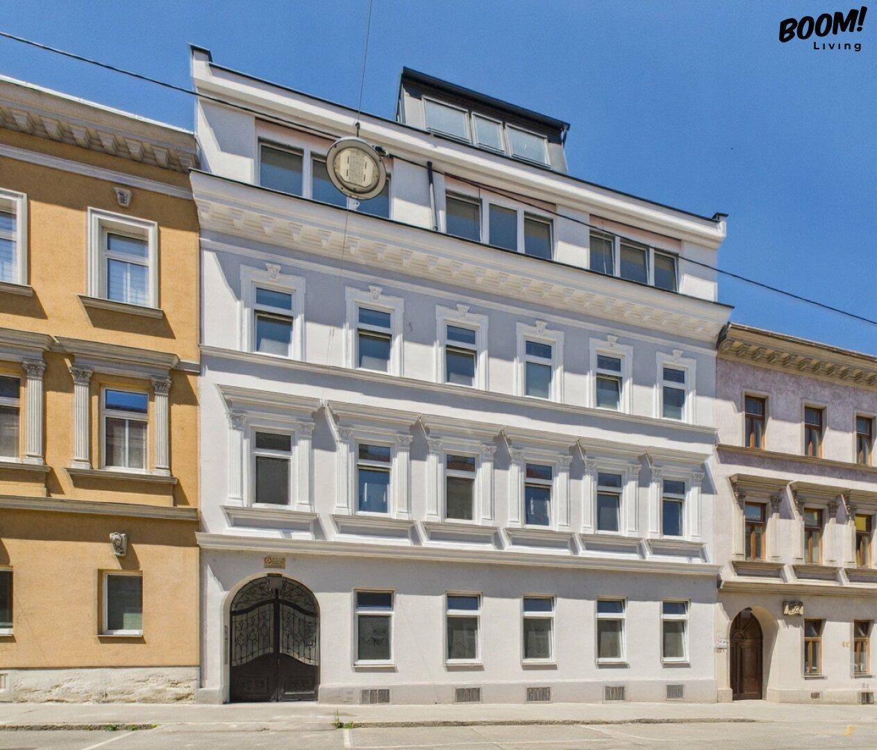 Mehrstöckiges Gebäude mit klassischer Fassade, modernen Dachaufbauten und gepflegtem Erscheinungsbild.