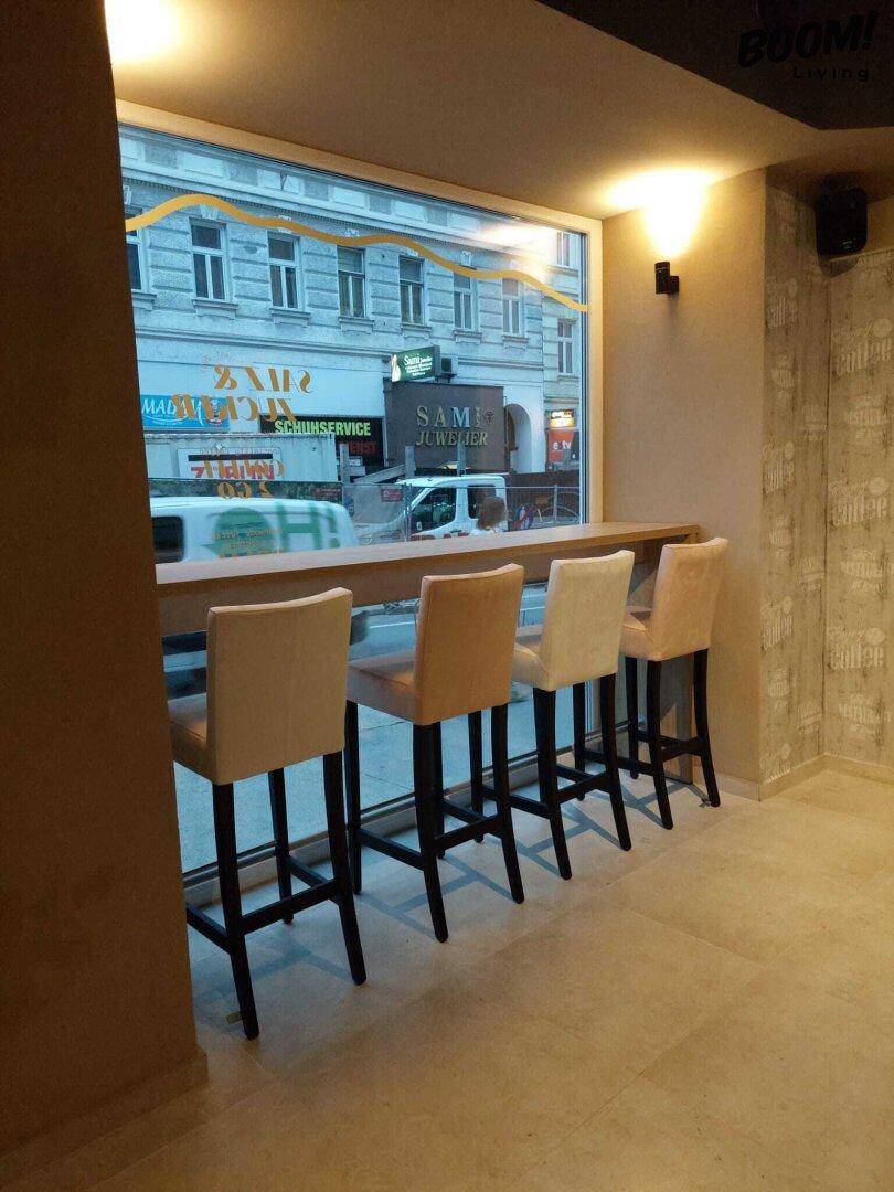 Sitzgelegenheiten am Fenster mit Blick auf die Straße, ausgestattet mit Barhockern und einer Theke.