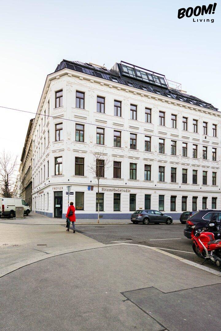 Elegantes Eckgebäude mit klassischer Fassade und modernen Dachfenstern in der Stadt.