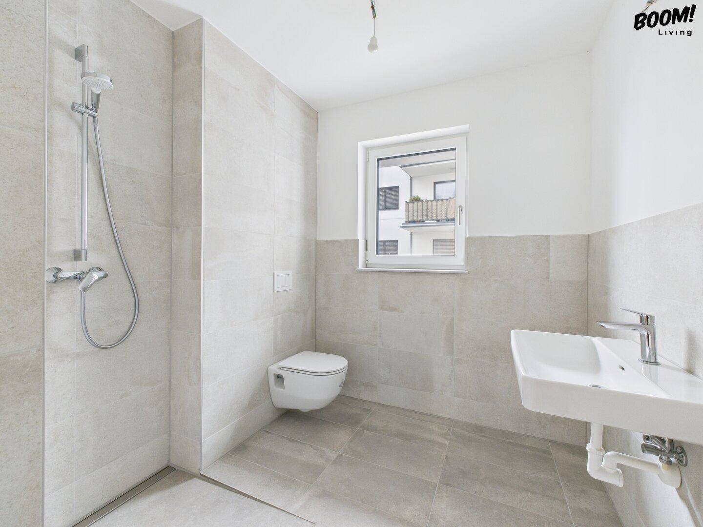 Modernes Badezimmer mit begehbarer Dusche, Wand-WC und Fenster für Tageslicht.