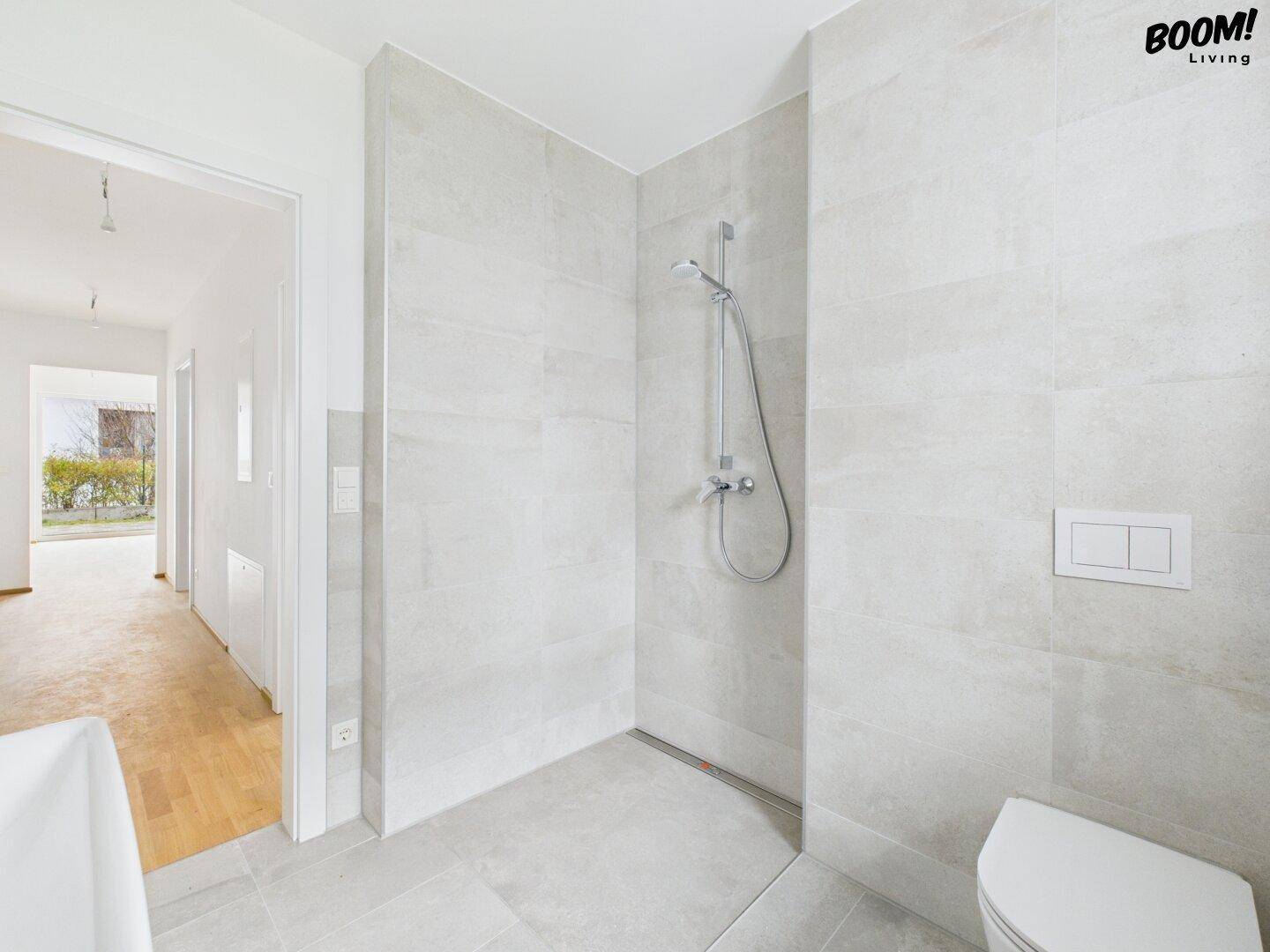 Modernes Badezimmer mit begehbarer Dusche und Fliesenboden, hell und funktional.