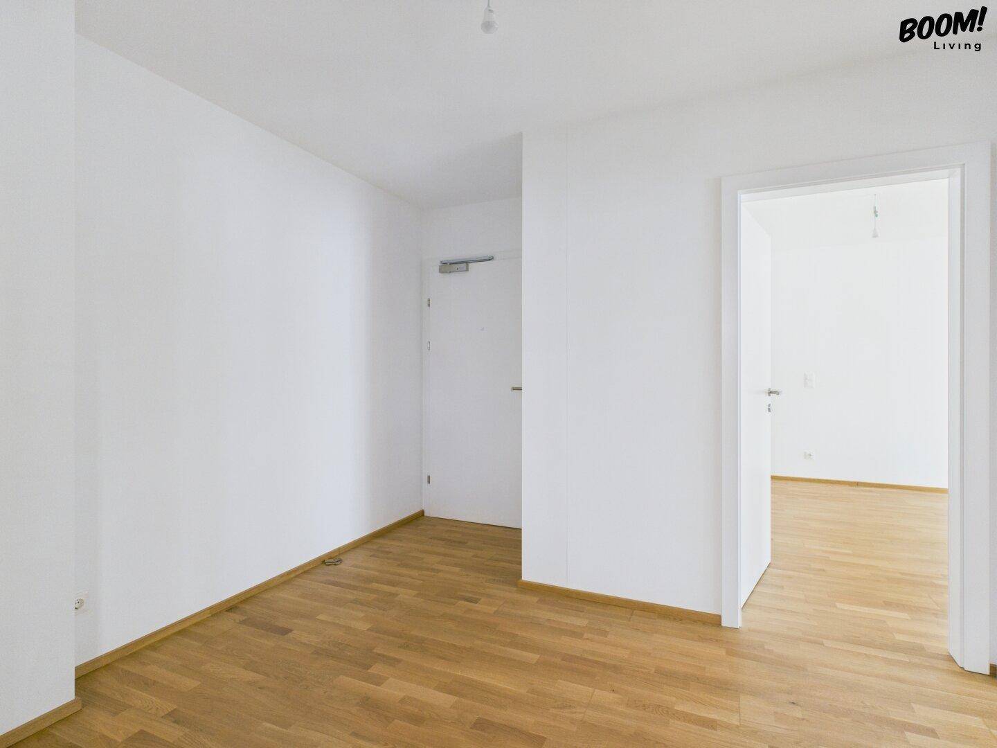 Heller Flur mit Holzboden und Türen zu angrenzenden Räumen.