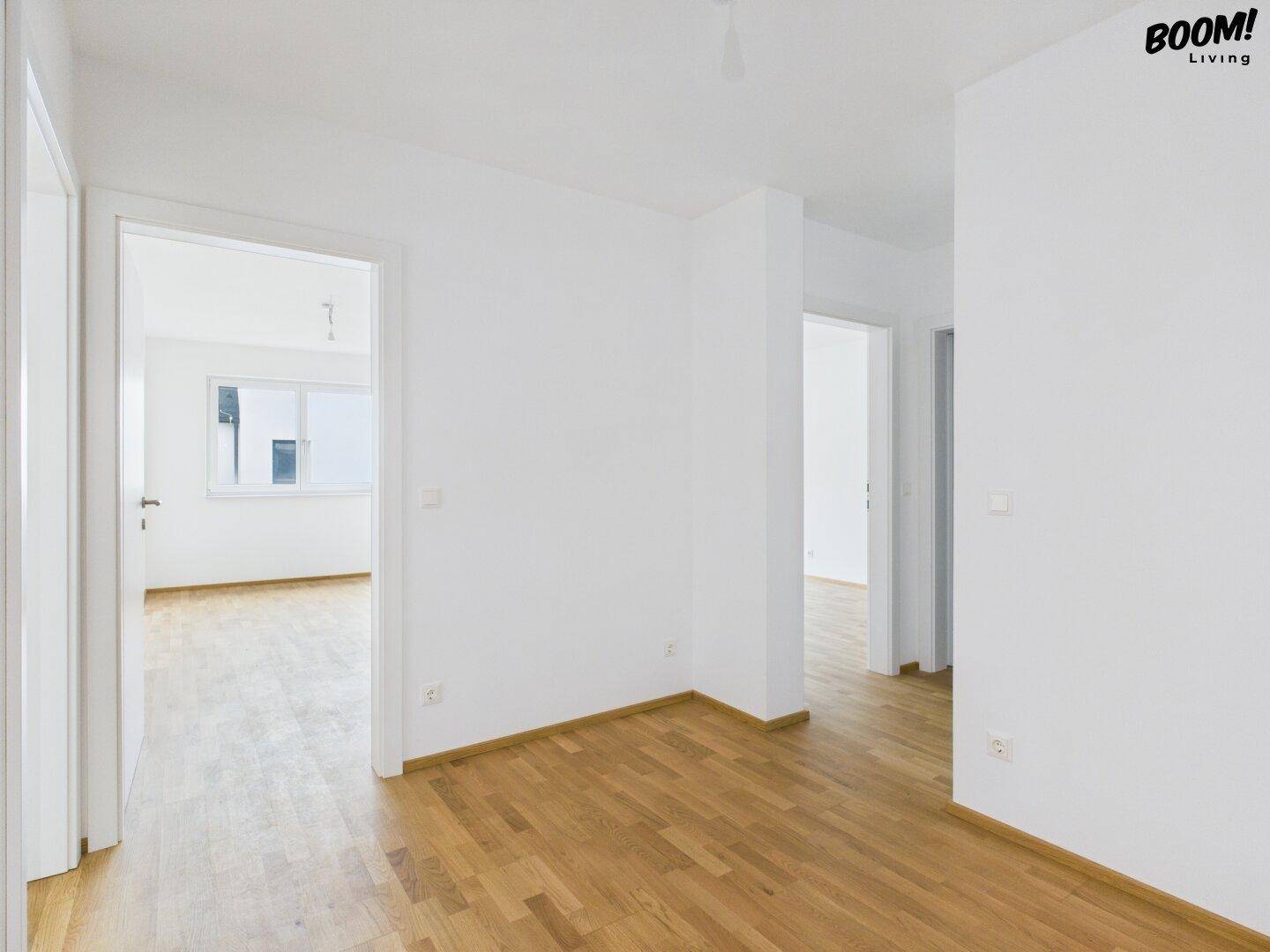 Geräumiger Flur mit Holzboden und mehreren Türöffnungen zu weiteren Zimmern.