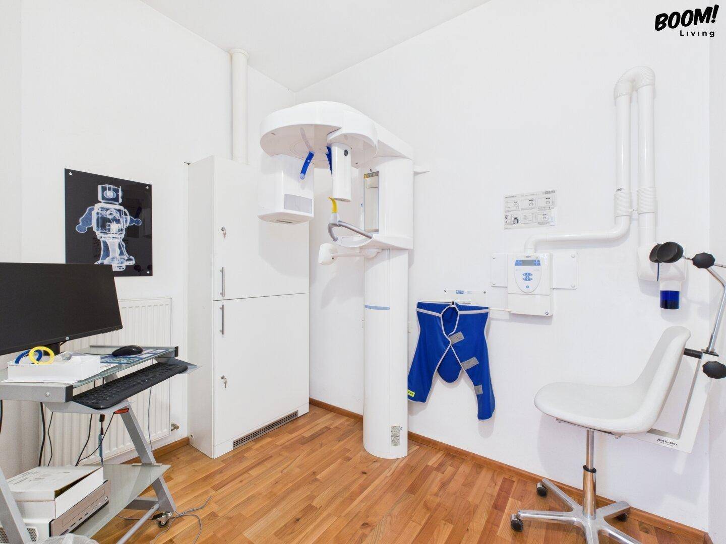 Raum mit zahnmedizinischem Röntgengerät, Computerarbeitsplatz und hellem Holzfußboden.