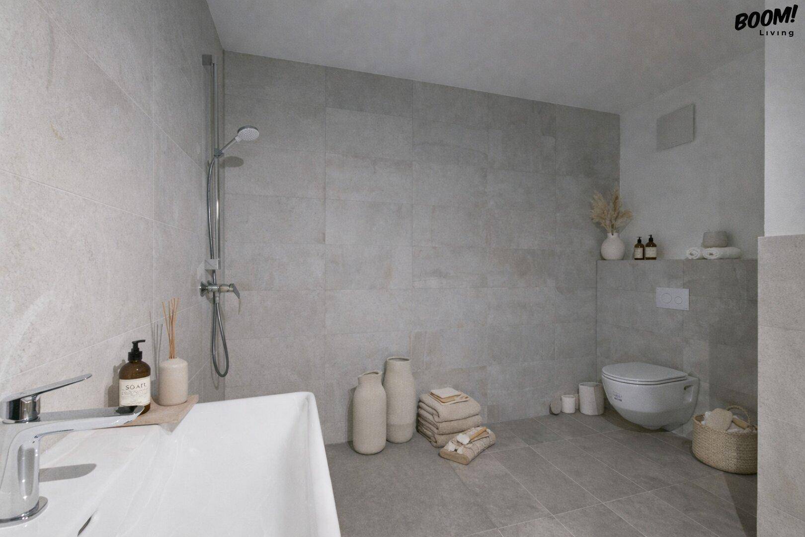 Modernes Badezimmer mit grauen Fliesen, wandhängendem WC und begehbarer Dusche.