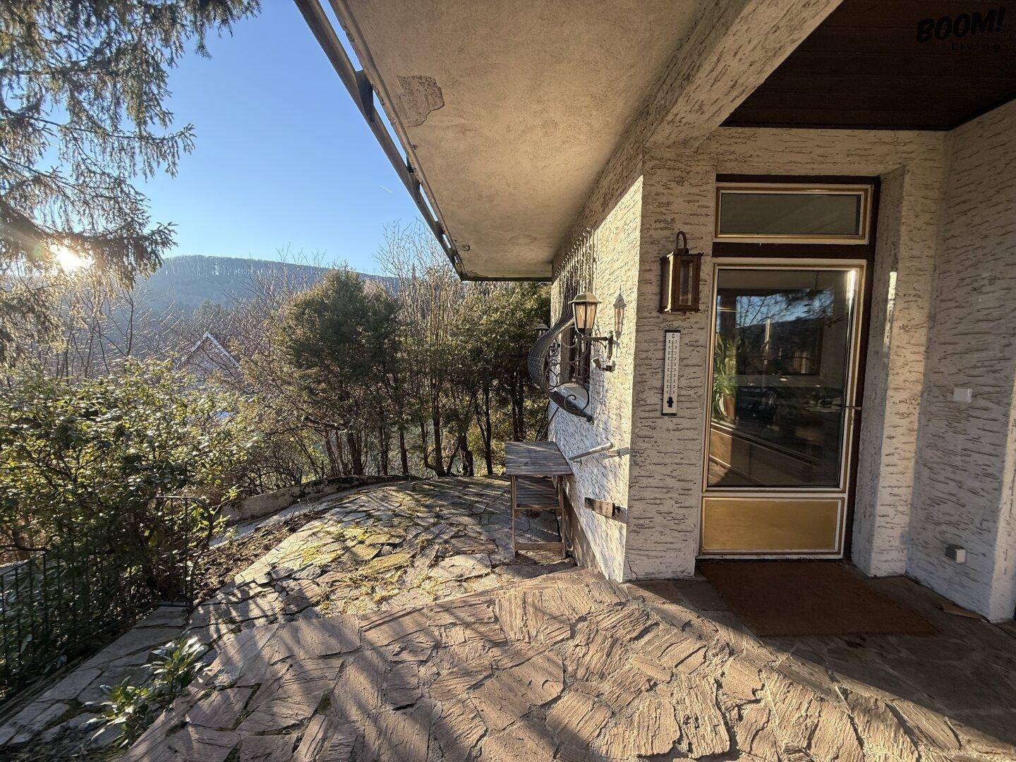 Sonniger Außenbereich mit Steinplatten und weitem Blick in die Landschaft.