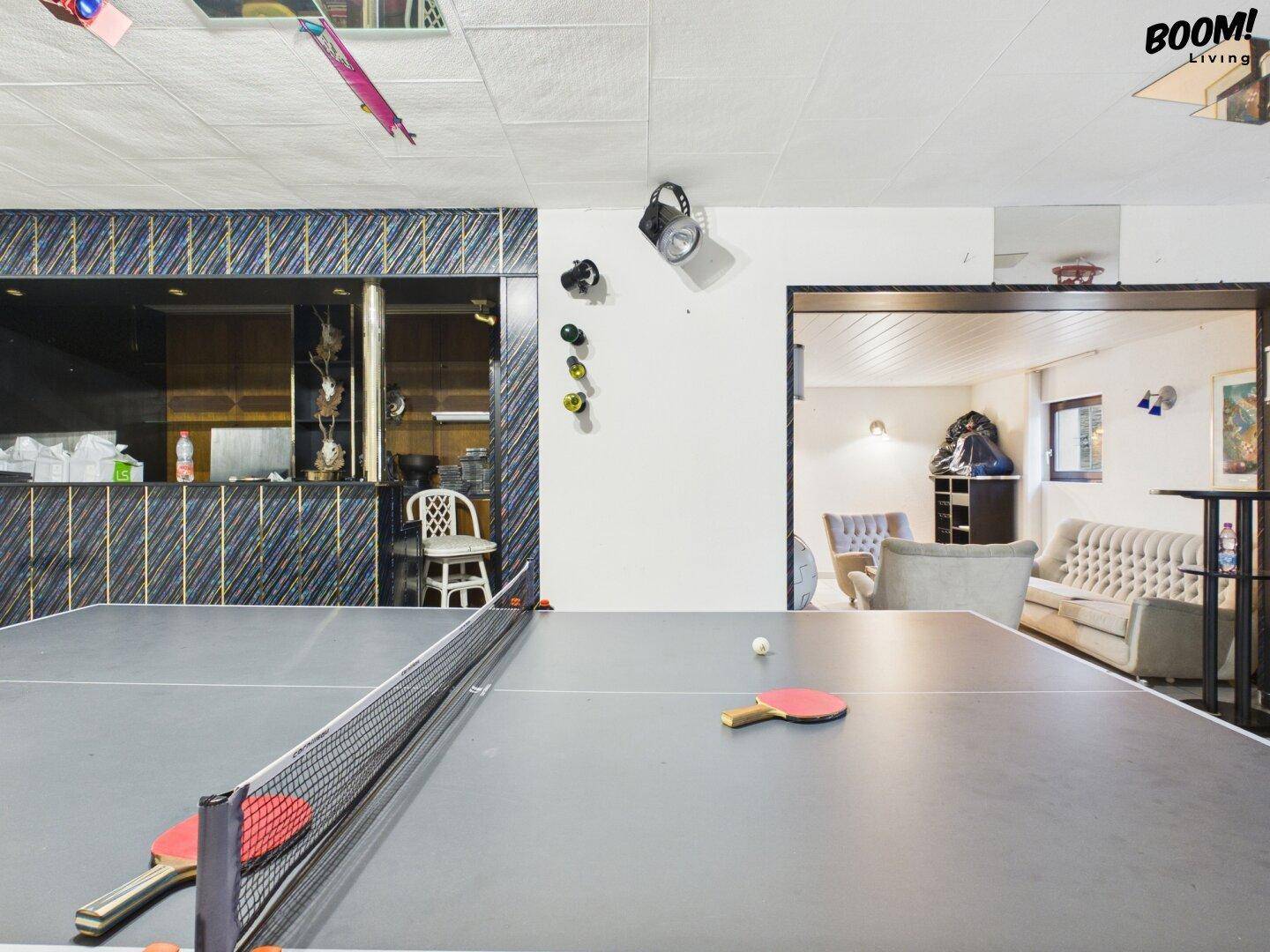 Unterhaltungsraum mit Tischtennisplatte und Bar, ideal für gesellige Abende.