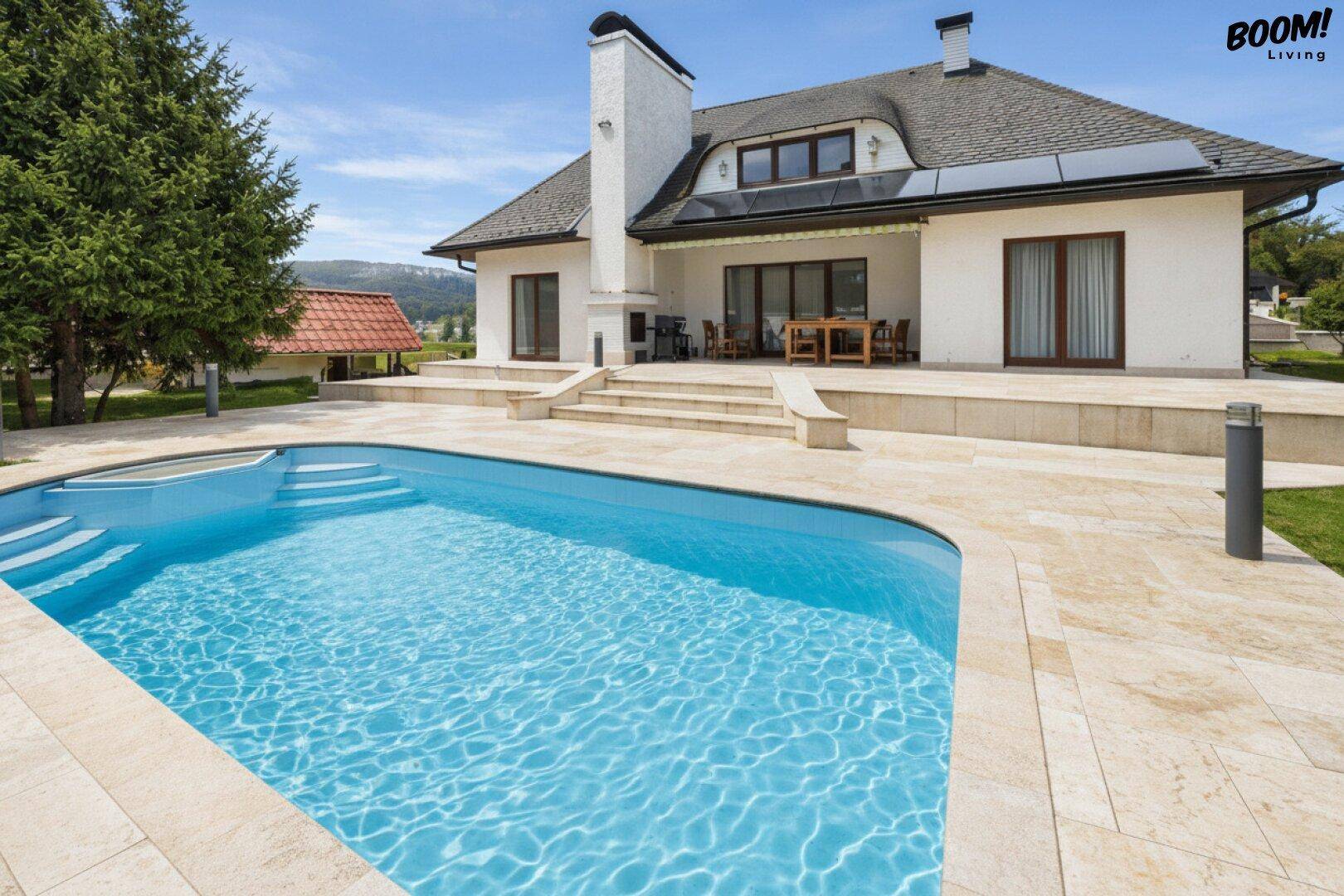 Großzügiger Außenbereich mit Swimmingpool, Sonnenterrasse und Blick auf die umliegende Natur.