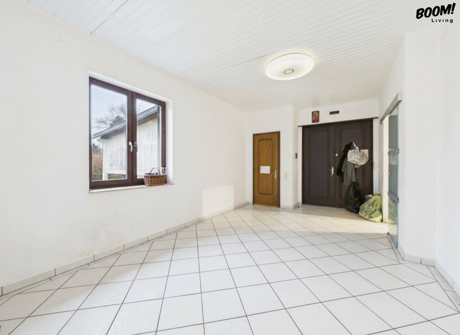 Heller Eingangsbereich mit Fliesenboden und Fenster, der zum Haus führt.