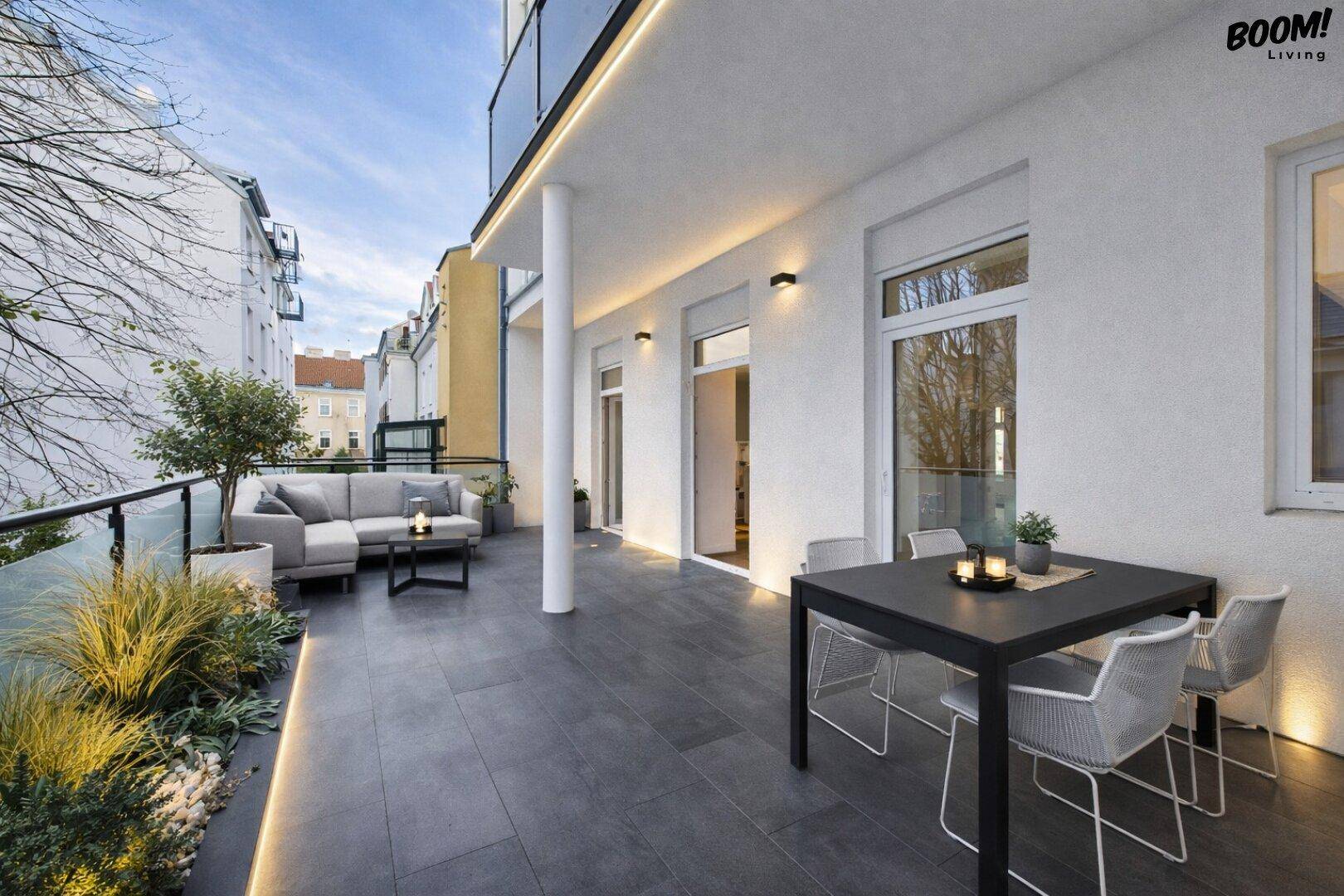 Geräumige Terrasse mit Lounge-Bereich, Esstisch und Pflanzen, ideal für Entspannung im Freien.