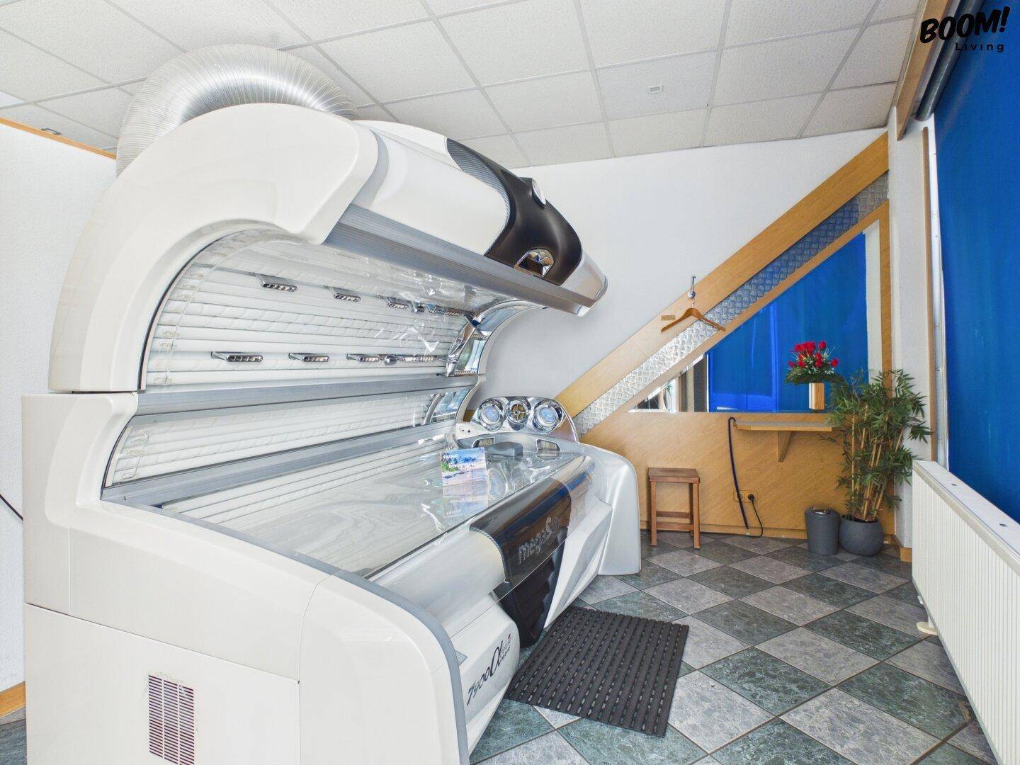 Ein Raum mit einem Solarium, ausgestattet mit Fliesenboden und einem Fenster für natürliche Belüftung.