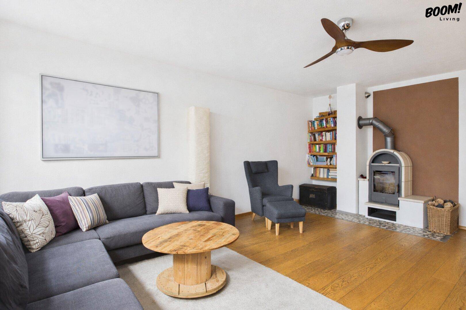 Wohnzimmer mit Holzboden, Kaminofen und integriertem Bücherregal für gemütliche Abende.