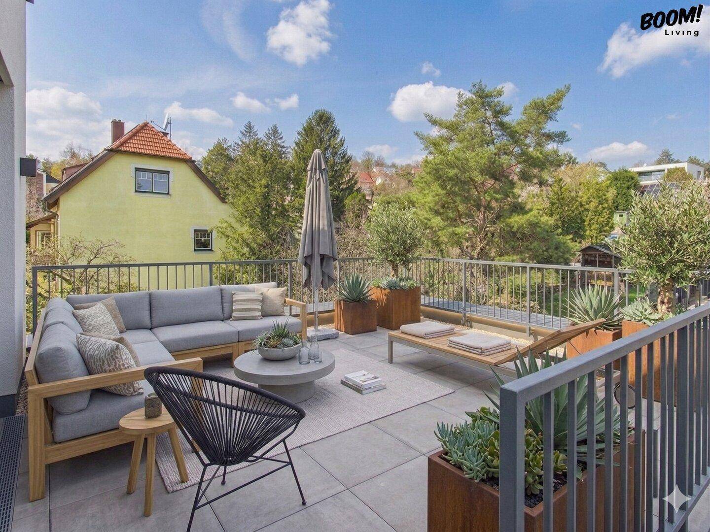 Große Dachterrasse mit bequemen Lounge-Möbeln und weitem Blick ins Grüne.
