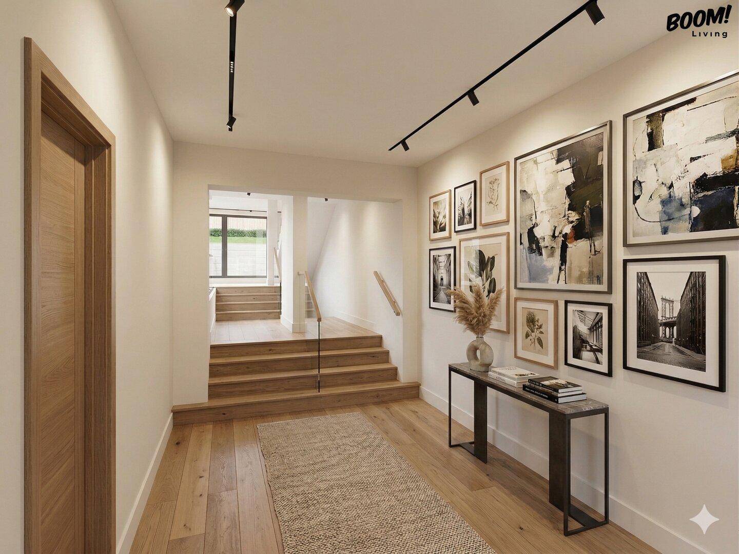 Heller Flur mit Holztreppe, Parkettboden und moderner Kunst an den Wänden.