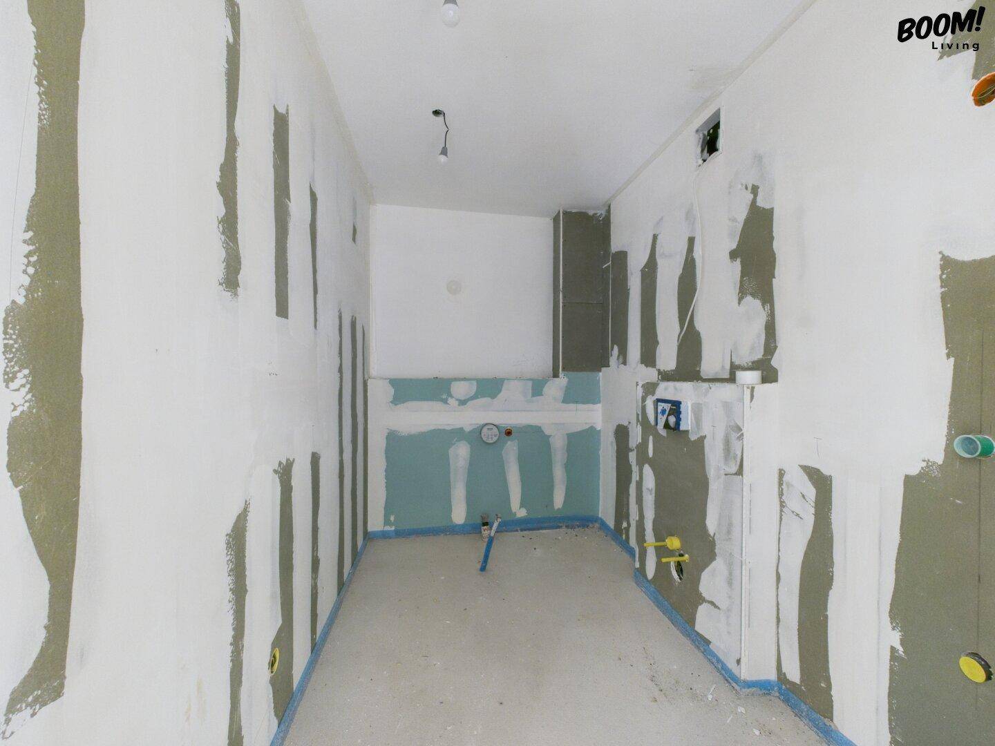 Rohbau-Badezimmer mit vorbereiteten Anschlüssen für Sanitärinstallationen.