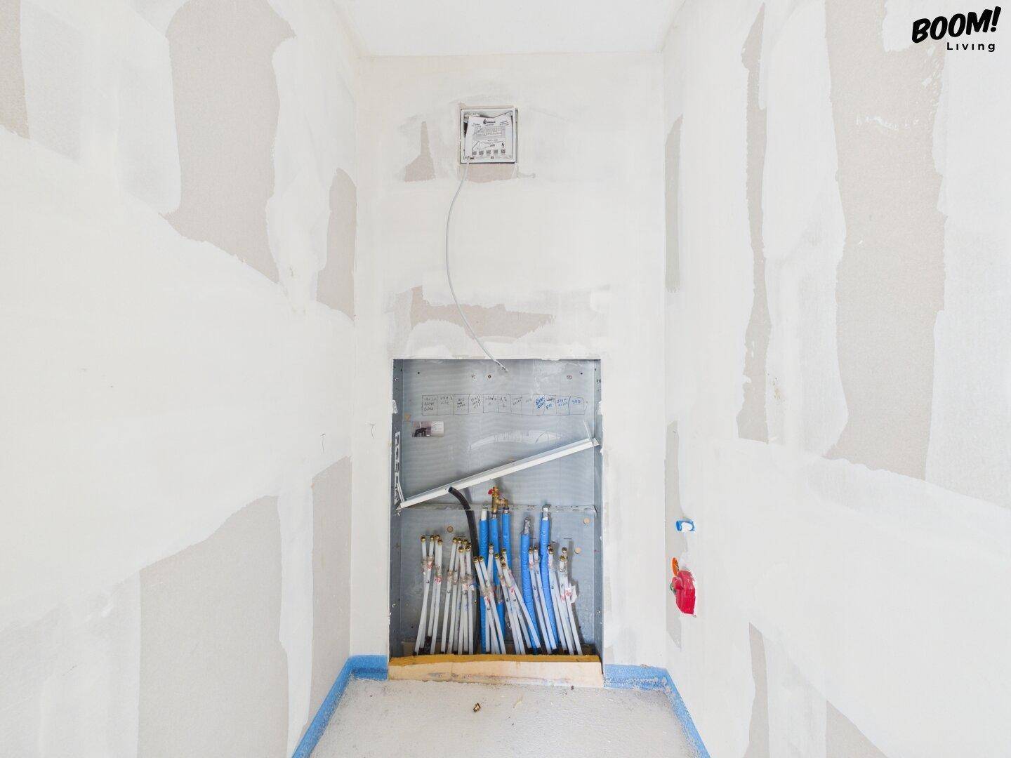 Rohbau eines Hauswirtschaftsraumes mit sichtbaren Rohrleitungen und Installationen.